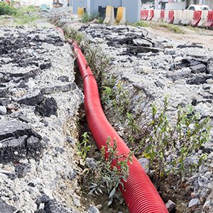 Underground trench with corrugated plastic sewage piping at infrastructure construction site