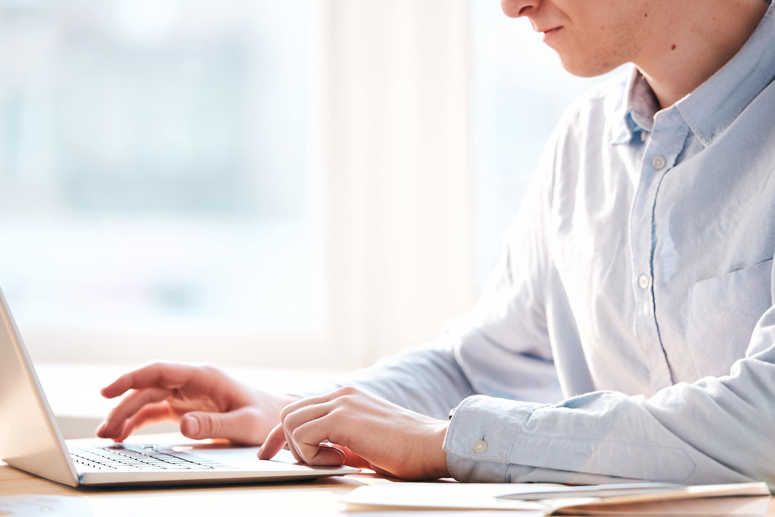 close up of man on laptop typing